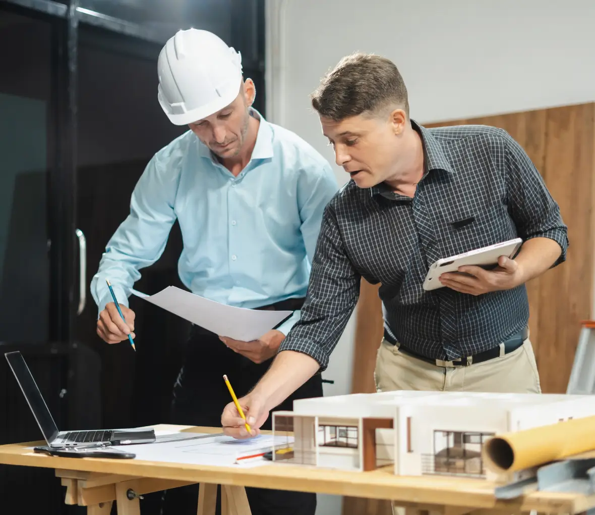 Architect and contractor reviewing house model plans
